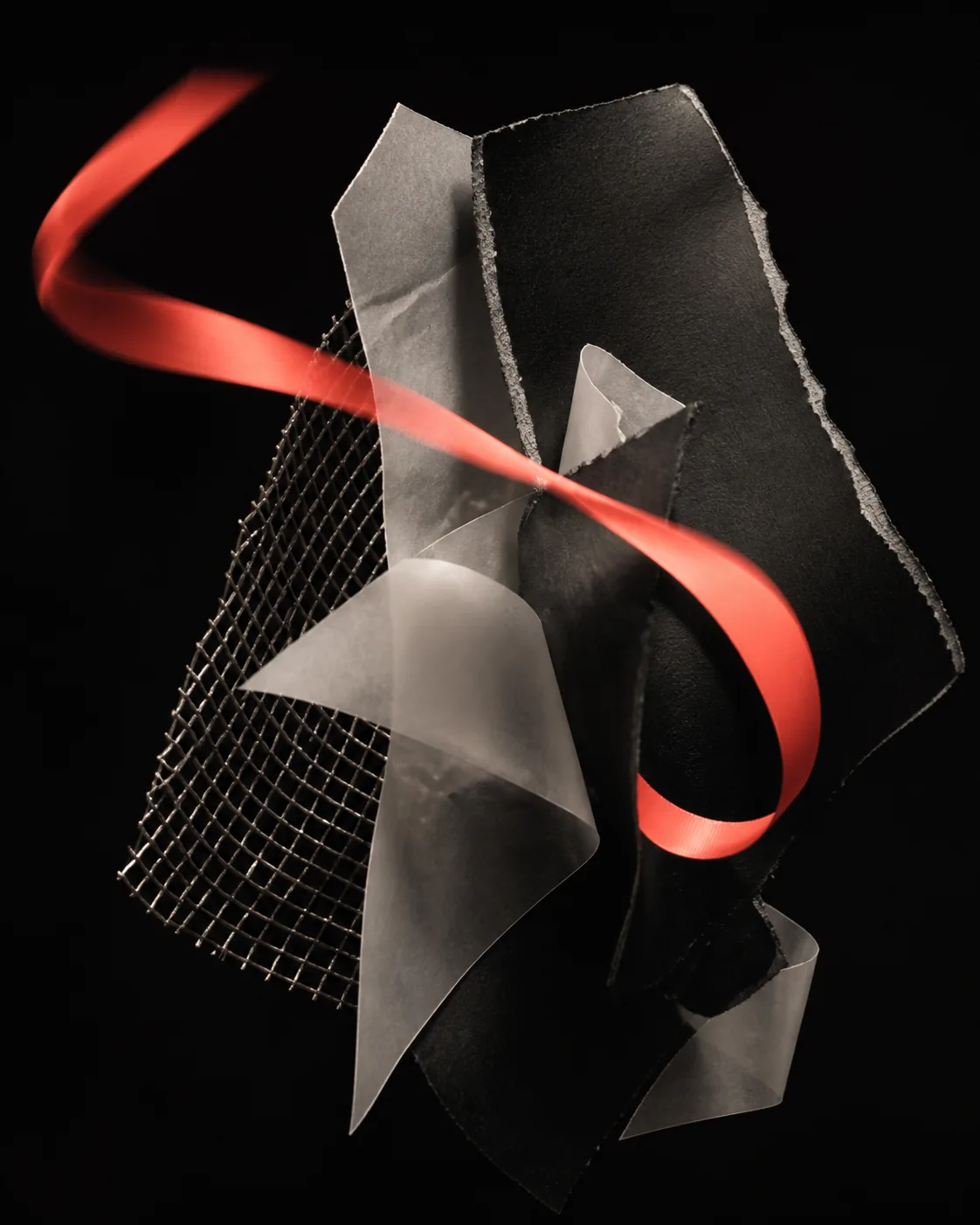 Abstract composition of paper, metal mesh, and coral ribbon